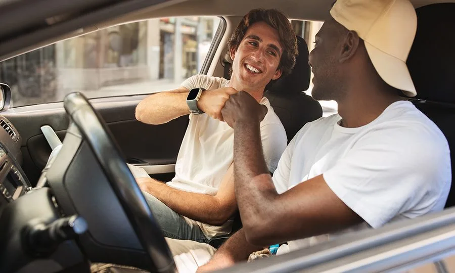 Two friends in a clean car, enjoying the gift of a great car wash
